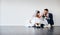 How excited are you. Studio shot of a newly married young couple sitting together on the floor against a gray background