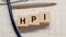 HPI word written on wooden blocks and stethoscope on light white background