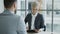 HR businesswoman having job interview with young man in suit and watching his resume application in modern office