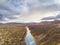 Hraunfossar series of waterfalls barnafoss aerial image of turquoise water next to lava field and the highlands of Iceland