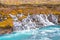 Hraunfossar series of waterfalls barnafoss turquoise groundwater collecting into plunge pool during autumn