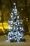 Ð¡hristmas tree outdoors with decorations, defocused bokeh lights