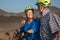 Hsppy senior couple with a yellow helmet enjoying a hike outdoors with their bicycles. Activity and healthy lifestyle concept