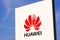 Huawei logotype on white panel sign by headquarters with clear blue sky