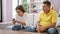 Huddled together at home, father and daughter share a serene indoor moment, sitting on the sofa, engrossed in using smartphone