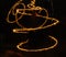 Hudozhniki juggling with two flaming poi\'s on fire. Prolonged exposure causes painting with light. Background.