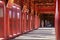 Hue / Vietnam, 17/11/2017: Woman passing through a red ornamental pavillion in the Citadel complex in Hue, Vietnam