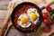 Huevos rancheros closeup in the pan and ingredients, horizontal