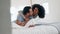 Hug, talking and couple in bed, happy and bonding together in home to cuddle. Embrace, interracial love and man and