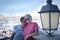 Hug between two smiling senior sisters. Couple of people, in vacation or retirement. Harbor and boats in background. Blue sky.