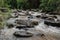 Huge active waterfall in green tropical mountain forest with people watching its flow, Bali. Hidden waterfall. Waterfall landscape