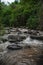 Huge active waterfall in green tropical mountain forest with people watching its flow, Bali. Hidden waterfall. Waterfall landscape