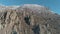 Huge and bizarre shapes of mountain rocks surrounded by snowed shrubs and trees against blue sky. Shot. Close-up.