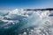 Huge broken pieces of ice frozen into the ice of Lake Baikal glisten in the sun.