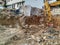 Huge bulldozer excavator of working among the dirty ground of excavation site while digging on the construction place