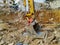 Huge bulldozer shovel head among the dirt and mud of excavation site while digging on the construction place