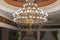 Huge chandelier in the hall. Chandelier on decoarted ceiling of a ballroom