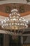 Huge chandelier in the hall. Chandelier on decoarted ceiling of a ballroom. vertical photo.