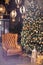 A huge Christmas tree in yellow lights, next to a cozy brown chair and lanterns