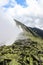 A huge cloud envelops the green Carpathian mountains