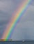 Huge colorful rainbow and a lonely boat