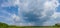 Huge comulus clouds with rain above a green prairie