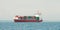 Huge container tanker ship carrying truck size colourful containers in deep blue open ocean sea