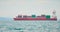 Huge container tanker ship carrying truck size colourful containers in deep blue open ocean sea