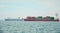 Huge container tanker ship carrying truck size colourful containers in deep blue open ocean sea