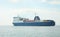 Huge container tanker ship carrying truck size colourful containers in deep blue open ocean sea