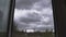 Huge dramatic thunderstorm clouds fly in the sky outside the window