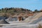 Huge dump truck driving past mountains of gravel