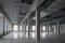 Huge empty open space in the old factory building with rows of columns, large windows and pipes under the ceiling