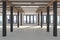 A huge empty room with large windows  overlooking the metropolis, iron columns and wooden beams in the loft style. Concrete floor