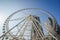 A huge ferris wheel in a modern city against blue sky