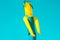 Huge figure of inflatable turquoise and yellow tube man skydancer moving in the air on blue sky background. Kids festival party