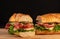 Huge fresh crispy baguette sandwich with meat, prosciutto, cheese, lettuce salad and vegetables. Close up. Black background. Space