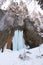 Huge frozen waterfall with a woman next to it at Seven Ladders Canyon Sapte Scari in Timisul de Jos, Piatra Mare mountains.