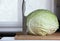 Huge head of juicy cabbage lies on a cutting board, next to it is a large vegetable knife. Cooking sauerkraut