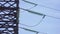 Huge high-voltage electrical pylons against a blue sky close-up