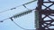 Huge high-voltage electrical pylons against a blue sky close up