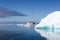 Huge Iceberg, with beautiful reflection in Arctic Ocean and small Cruise Ship, Greenland