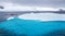 Huge iceberg with blue underwater part and small tourists kayaks with antarctic lagoon in the backgound, Peterman island,