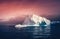 The huge iceberg on the colorful sky background.