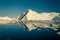 Huge iceberg in the Ilulissat icefjord and ice field reflects in the water