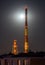 Huge industrial chimneys lit by a full moon