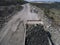 Huge industrial dump truck in a stone quarry loaded granite shot from a drone