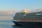 Huge luxury cruise ship glides out of the port of Koper during magic sunrise. Colorful vibrant sky. Travel and tourism concept.