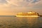 Huge luxury cruise ship glides out of the port of Koper during magic sunset. Colorful vibrant sky. Travel and tourism concept.