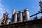 Huge metal blast furnaces of an industrial steel mill, beautiful blue sky and bright sunlight